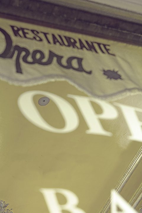 Detalle del letrero esmerilado Restaurante Opera sobre el cristal de la entrada